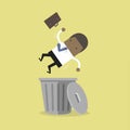 African businessman works on laptop and a win jackpot, financial success.African businessman dropped into trashcan layoff concept.
