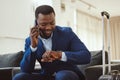 African businessman in hotel, on smartphone call and checking wrist watch for time. Corporate professional in Chicago Royalty Free Stock Photo