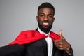 African businessman superman take selfie with thumbs up isolated on gray background