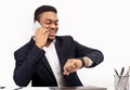 African businessman talking on phone looking at watch Royalty Free Stock Photo