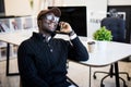 African businessman talking on smartphone and working in office sitting at his workplace Royalty Free Stock Photo