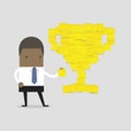 African businessman with trophy cup yellow sticky notes.