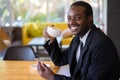 African Businessman Using smarphone In Coffee Shop