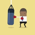 African businessman wearing boxing gloves and punching the punch bag. Royalty Free Stock Photo