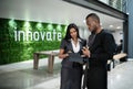 African businesspeople talking over a tablet in their office lobby Royalty Free Stock Photo