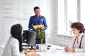 African businesswoman giving presentation to executive caucasian team in meeting room Royalty Free Stock Photo