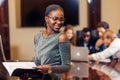 African businesswoman look at camera in boardroom with colleagues in background Royalty Free Stock Photo