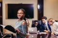 African businesswoman look at camera in boardroom with colleagues in background Royalty Free Stock Photo