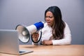 African businesswoman shouting in megaphone on laptop Royalty Free Stock Photo