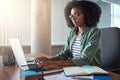 An african businesswoman typing on laptop at her office desk