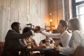 African and caucasian men handshaking at coffeehouse meeting wit