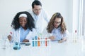African and Caucasian scientist girl students are doing science experiments in laboratory with Asian teacher man Royalty Free Stock Photo