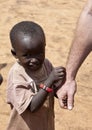 African child holds aid worker's hand