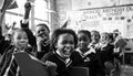 African children in a classroom, raising hands and laughing in the Primary school in South Africa Royalty Free Stock Photo