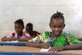 Beautiful African Girl Candid Photo looking at camera in classroom in African school Royalty Free Stock Photo