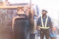 African civil engineering standing against the truck with holding tool box in hands. The technician working with use tablet for