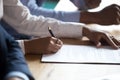 African client hand sign business contract at meeting, closeup view