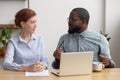 African company member training, brainstorming, sharing thoughts with female coworker Royalty Free Stock Photo