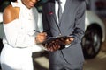 African couple getting car key from dealer in showroom and signing contract Royalty Free Stock Photo