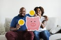 An African couple holding saving money icons home family saving investment concept Royalty Free Stock Photo