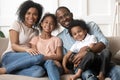 African couple little kids sitting on couch looking at camera Royalty Free Stock Photo