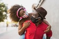 African couple piggyback wearing face mask - Happy Afro people having fun outdoor