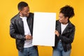 African Couple Showing Empty Poster With Blank Space, Yellow Background Royalty Free Stock Photo