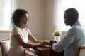 African couple sitting at table having heart-to-heart talk Royalty Free Stock Photo