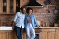 African couple standing in modern kitchen smile looking into distance Royalty Free Stock Photo