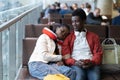 African couple of tourists in waiting area of airport terminal sit, nap before departure check-in Royalty Free Stock Photo