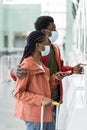 African couple travel during covid-19 outbreak. Black man and woman in masks on check-in in airport