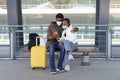 African couple travel in covid-19 sit wait for transfer or taxi from airport wearing medical masks Royalty Free Stock Photo