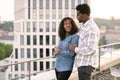 African couple woman and man hugging on rooftop of modern building. Royalty Free Stock Photo
