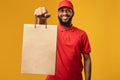 African Courier Giving Shopper Bag Delivering Food, Yellow Background