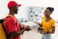 African Courier Guy Giving Pizza Box To Happy Female Indoor Royalty Free Stock Photo