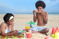 African curly hair boy and girl sibling on beach. Happy smiling two kid friend playing together on sand beach. Joyful children Royalty Free Stock Photo