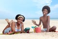 African curly hair boy and girl sibling on beach. Happy smiling two kid friend playing together on sand beach. Joyful children Royalty Free Stock Photo