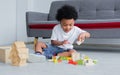 African cute boy playing toys, laughing and sitting on the floor in living room at home. Education and Lifestyle Concept Royalty Free Stock Photo