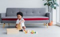 African cute boy playing toys, laughing and sitting on the floor in living room at home. Education and Lifestyle Concept Royalty Free Stock Photo