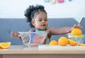 African cute kid girl squeezing fresh oranges at home. Adorable child happy to making freshly squeezed orange juice on manual Royalty Free Stock Photo