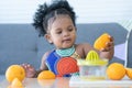 African cute kid girl squeezing fresh oranges at home. Adorable child happy to making freshly squeezed orange juice on manual Royalty Free Stock Photo