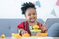 African cute kid girl squeezing fresh oranges at home. Adorable child smiling while making freshly squeezed orange juice on manual Royalty Free Stock Photo