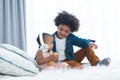 African cute newborn baby with headphones, sitting on bed, listening music with older brother at home. Little child boy spends Royalty Free Stock Photo