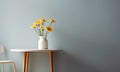 African daisy flowers in vase on white wooden coffee table against dirty blue wall background. Interior design of modern living Royalty Free Stock Photo