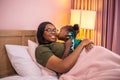 African daughter kissing her mum on the bed Royalty Free Stock Photo