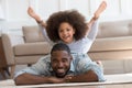 African daughter performs yoga boat pose on father back Royalty Free Stock Photo