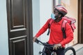 African delivery man with electric bike ringing the doorbell during coronavirus time - Focus on face