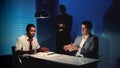 African detective questioning suspect caucasian man in interrogation room. Royalty Free Stock Photo