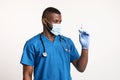 African doc in face mask and gloves looking at syringe Royalty Free Stock Photo