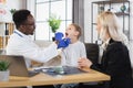 African doctor examining throat of little boy at hospital Royalty Free Stock Photo